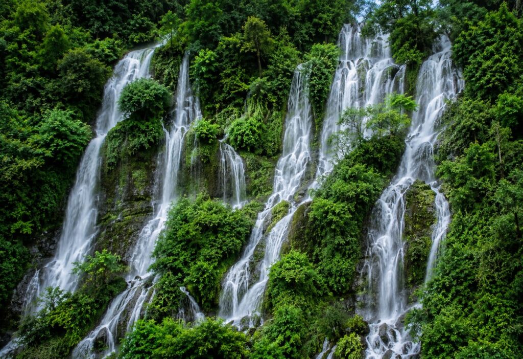Multi-tier waterfall surrounded by lush green forest in Lai Chau, northern Vietnam